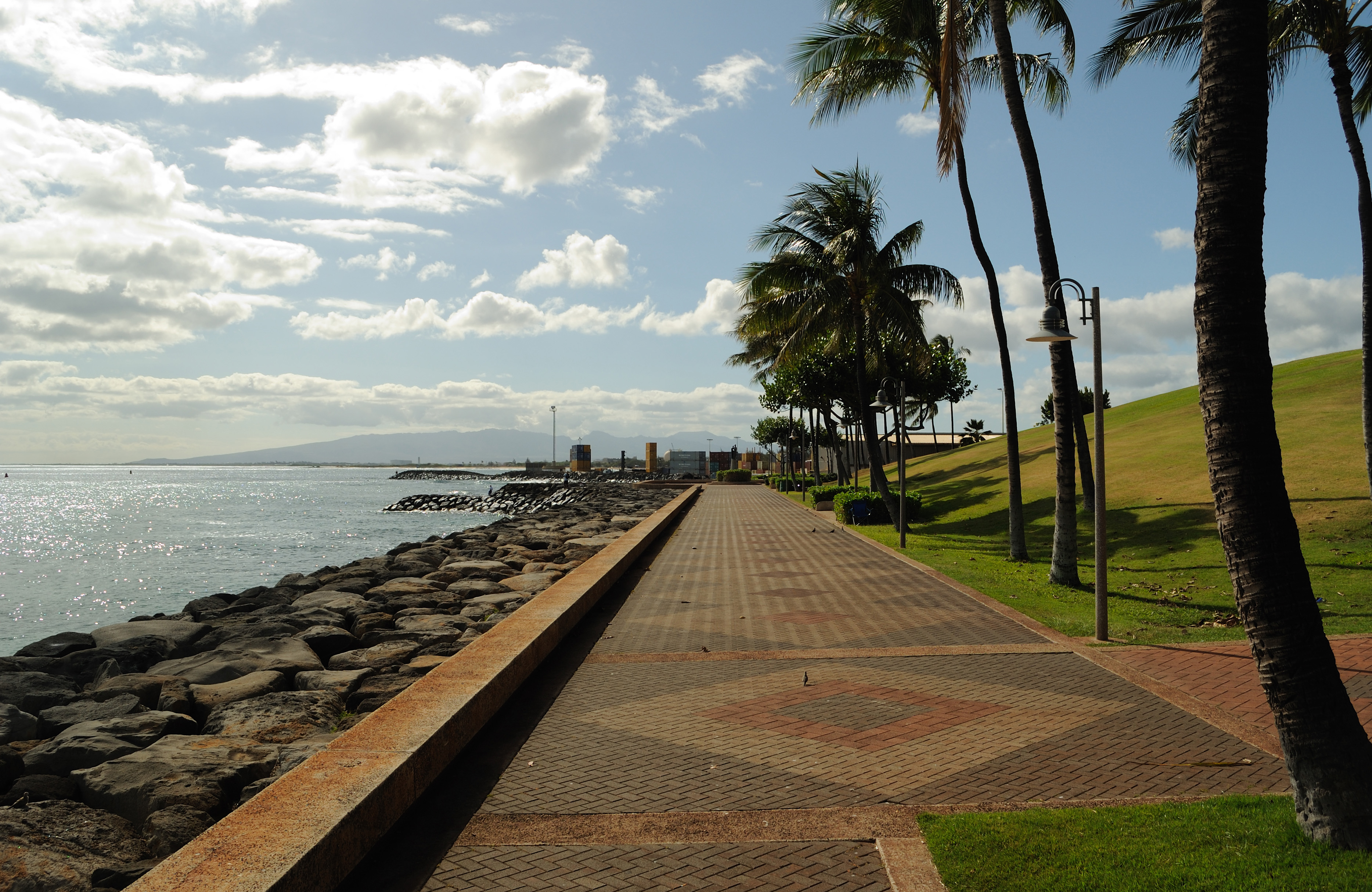Kakaʻako Waterfront Park 的 Northwest 方向全景，展示起伏草坡、promenade 和海岸线的关系