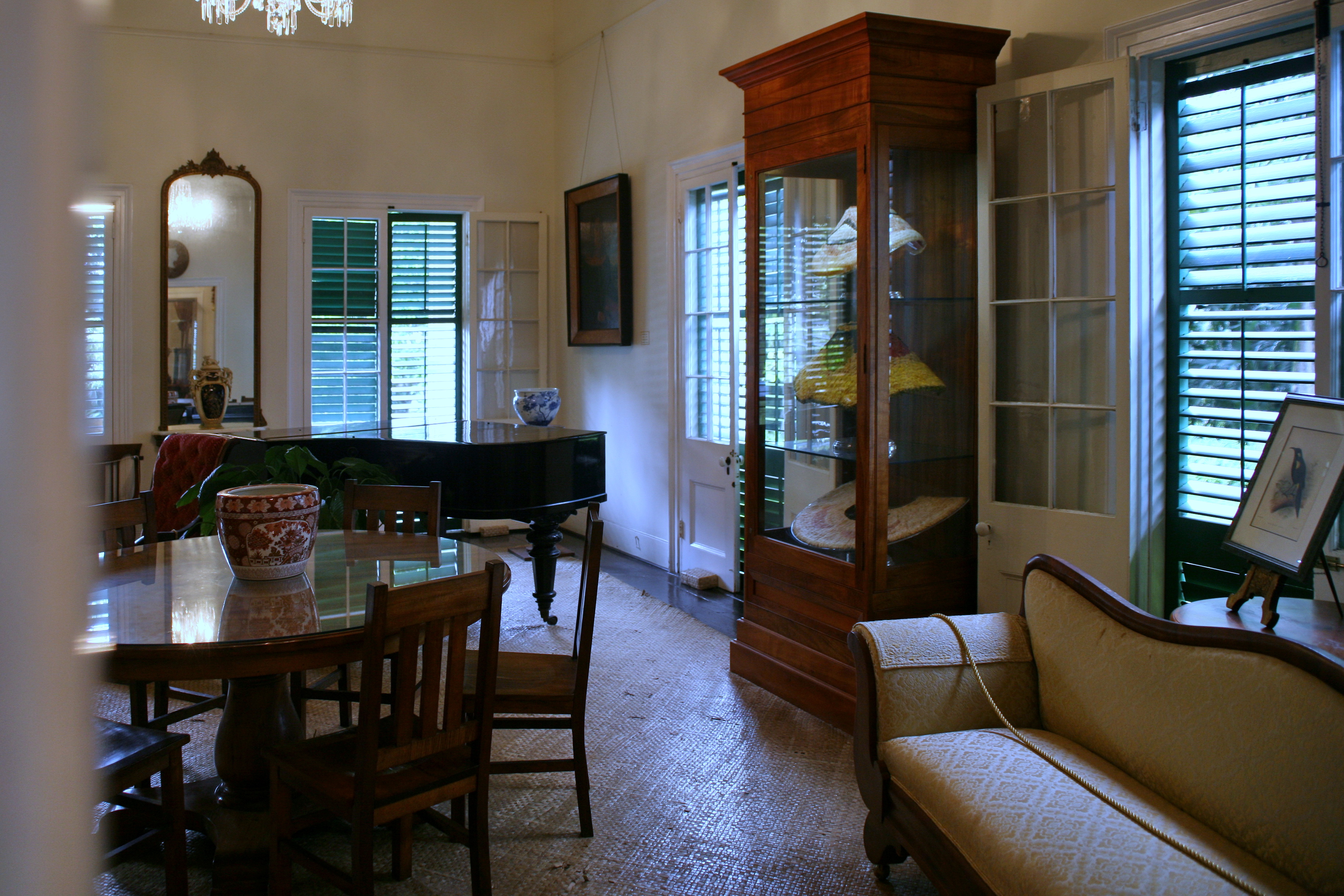 Queen Emma Summer Palace 的 parlor 室内，piano、koa table、cabinet 和 shutter