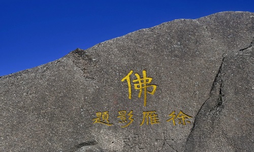 黄山摩崖石刻群，岩壁上刻有红色汉字，山间植被环绕