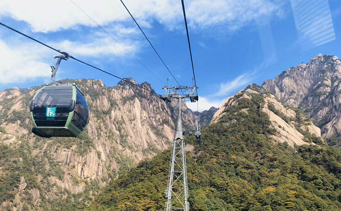 黄山索道远景：钢缆支架从山谷延伸至山顶，几乎隐蔽在山景中