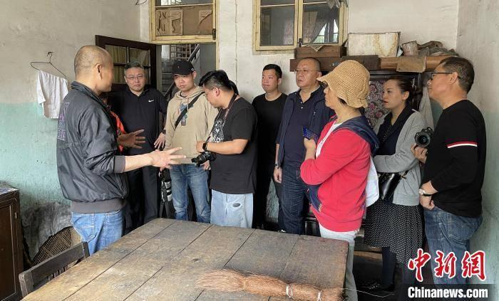 屯溪胡开文墨厂内，参观者围在工匠周围观看传统制墨演示
