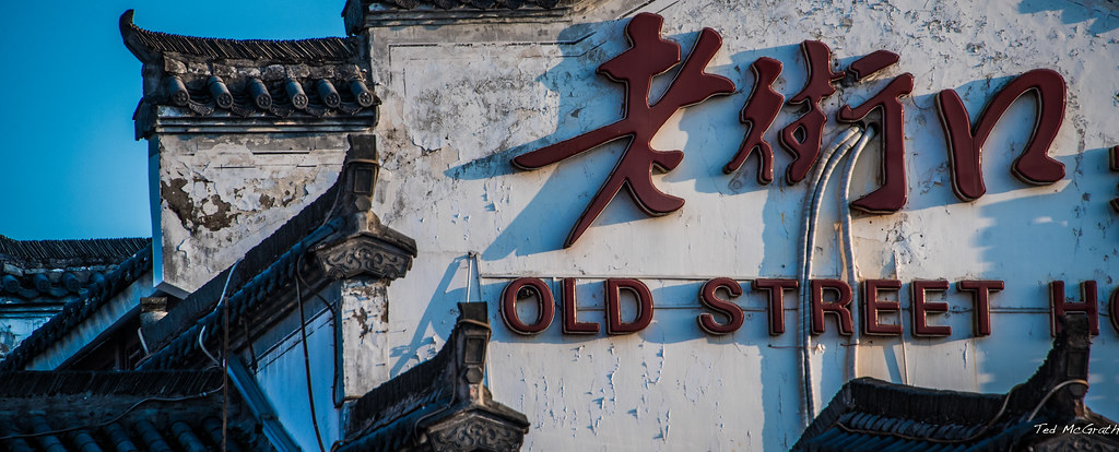 屯溪老街沿街店铺，可见木排门和黑底金字招牌
