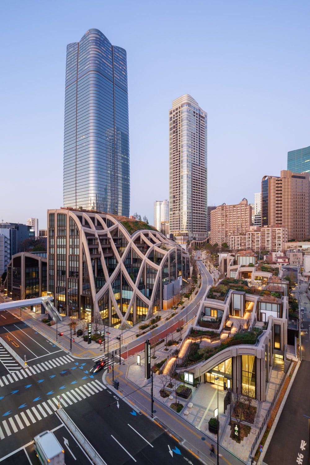中央广场绿地及 Heatherwick Studio 设计的低层建筑，背景为 Mori JP Tower