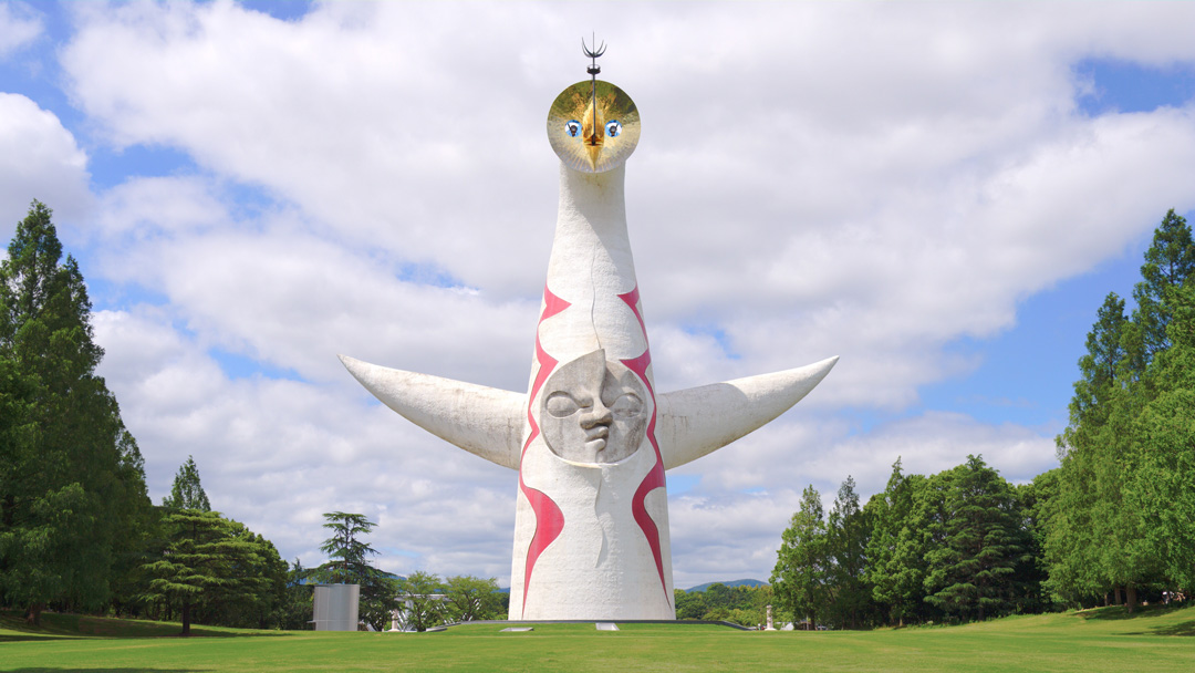 太阳塔正面全景，从公园广场方向可见三张脸和张开的手臂