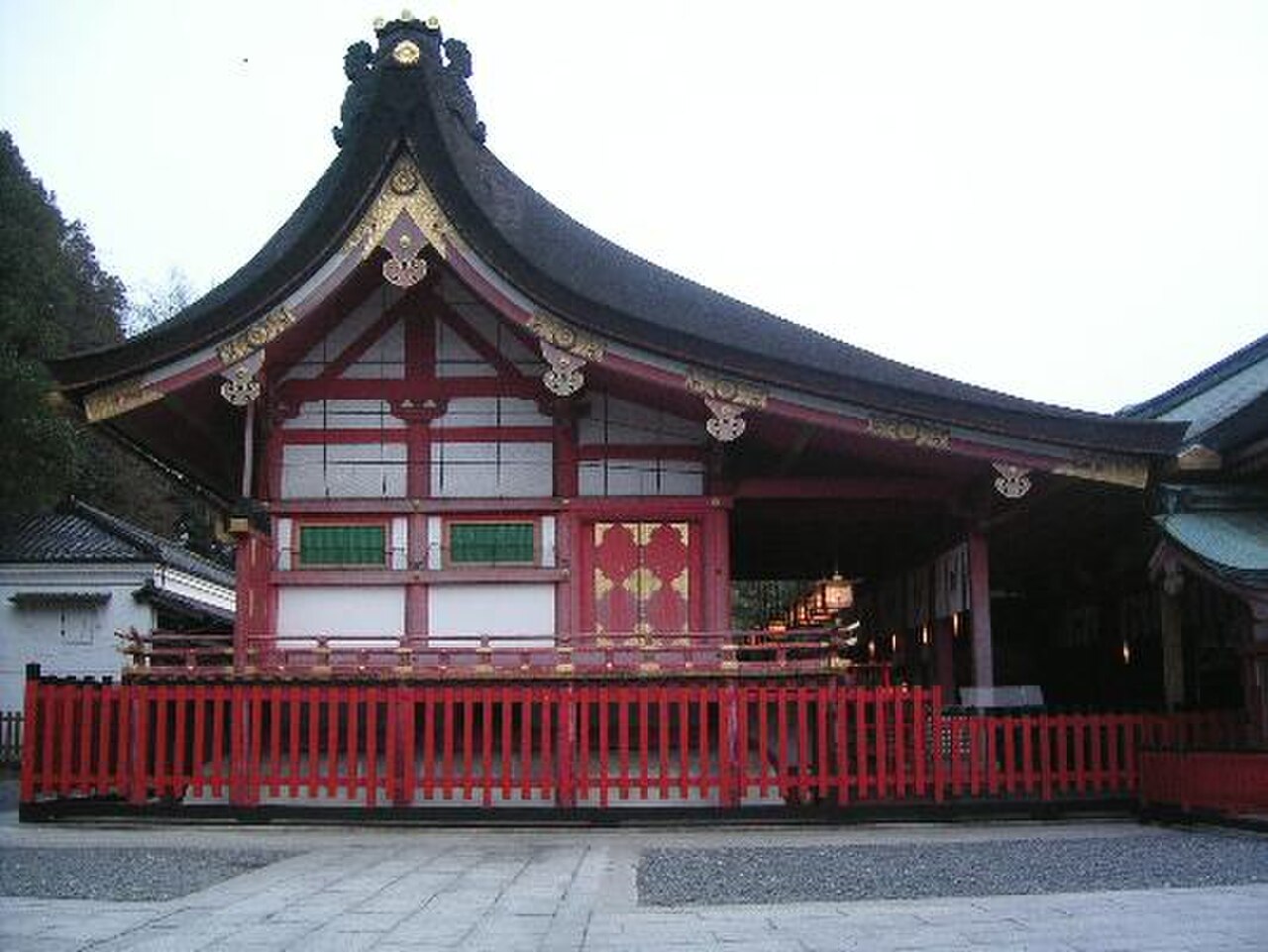 伏见稻荷大社本殿正面，曲线屋顶和金色装饰清晰可见