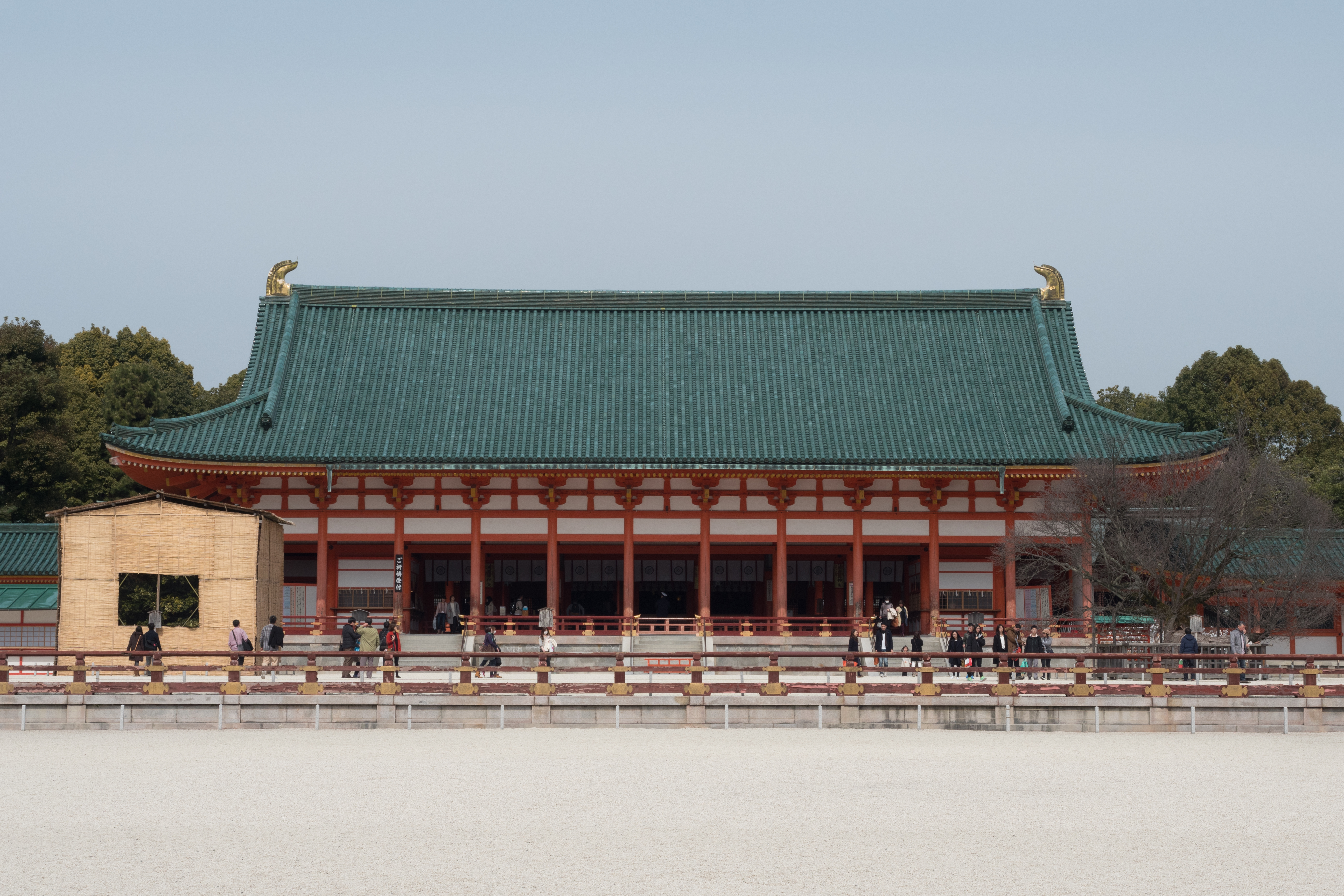 大极殿正面全景，朱红柱廊、绿瓦屋顶和白砂中庭左右对称展开