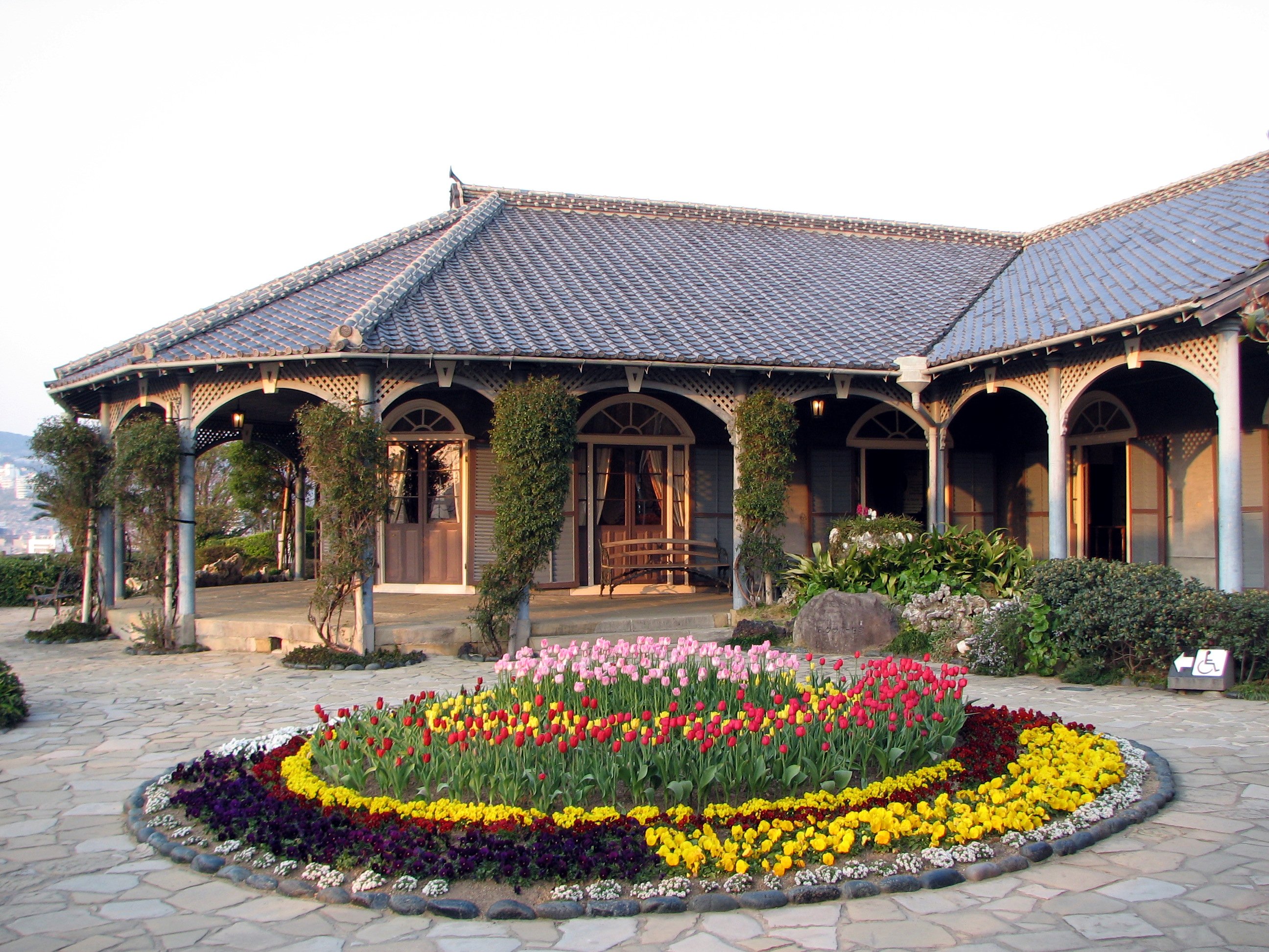 Glover House 外景，右侧可见 Mitsubishi 造船厂的起重机与港湾设施