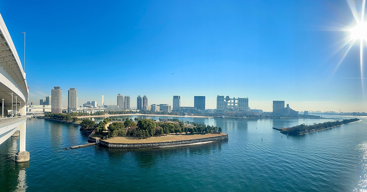 台场海滨公园望向彩虹桥，白色双层吊桥横跨东京湾