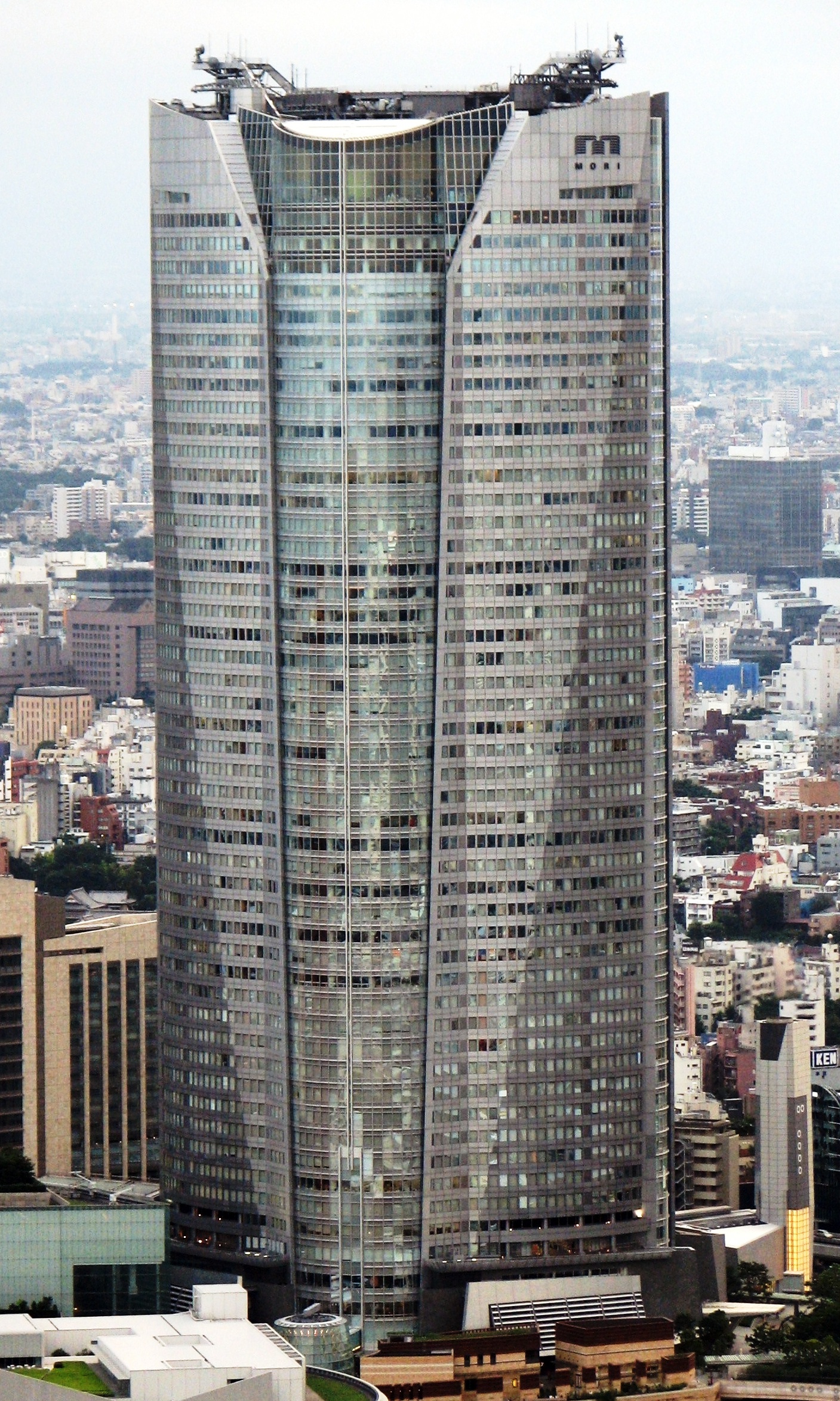 从东京塔方向看到的Roppongi Hills Mori Tower，238米高的玻璃塔楼在港区天际线中成为视觉焦点