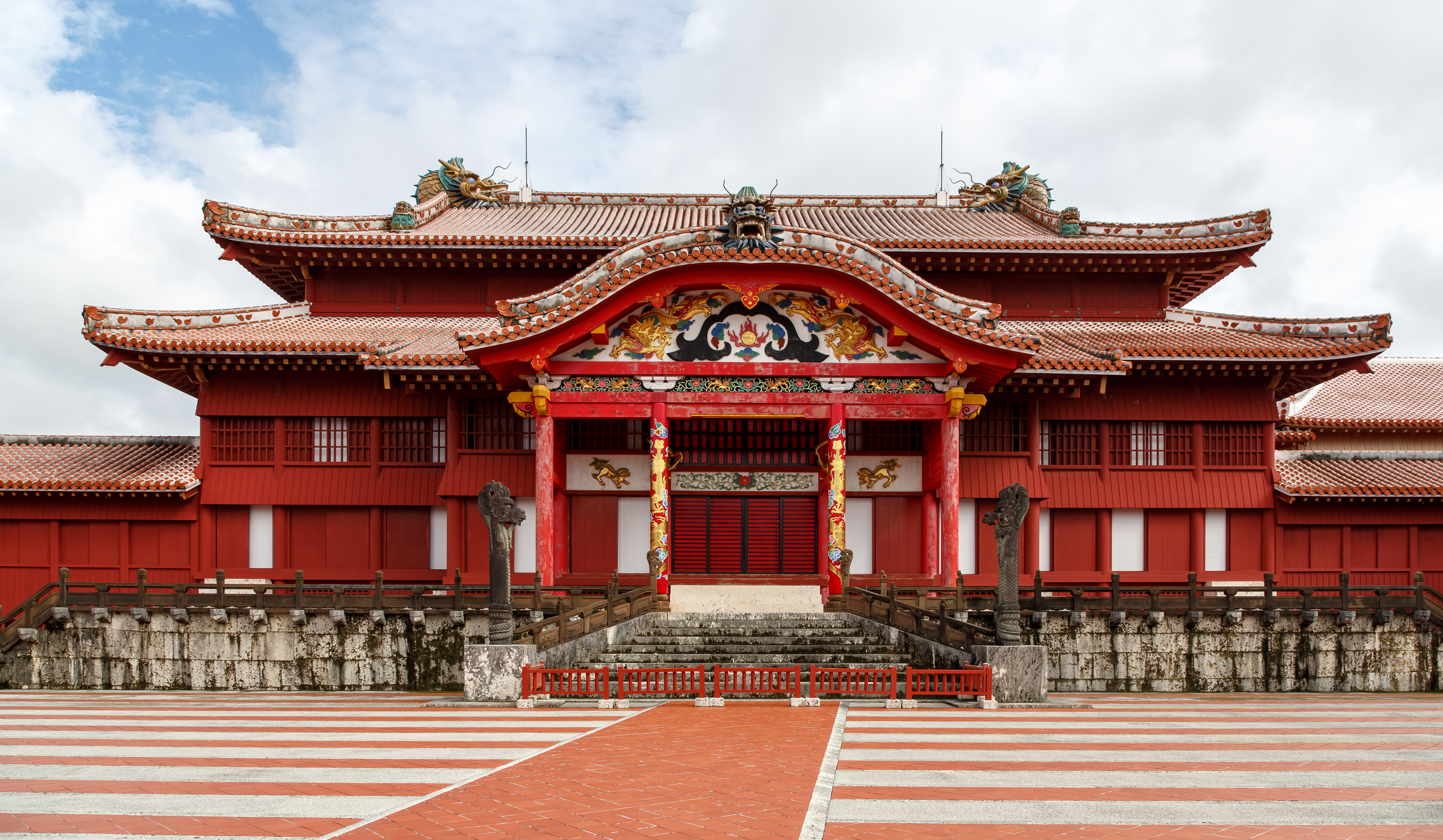 首里城正殿外景，朱红墙壁和红瓦屋顶，正面可见龙柱