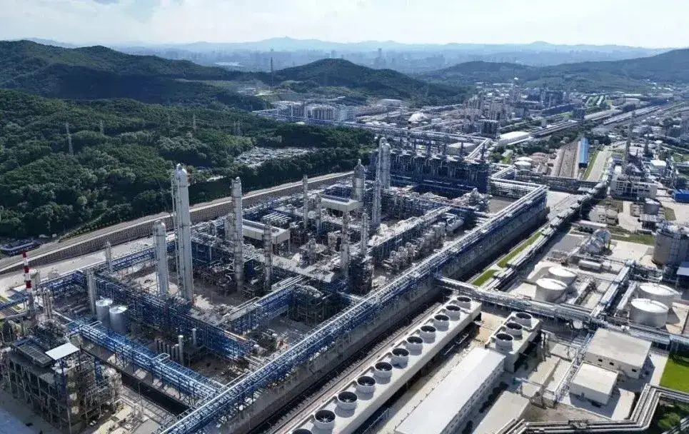 吉林石化厂区鸟瞰，可见蒸馏塔群、管廊网络、储罐和冷却塔