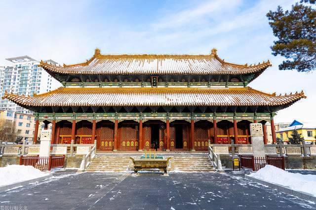 吉林文庙入口雪景，传统建筑与城市高楼叠合