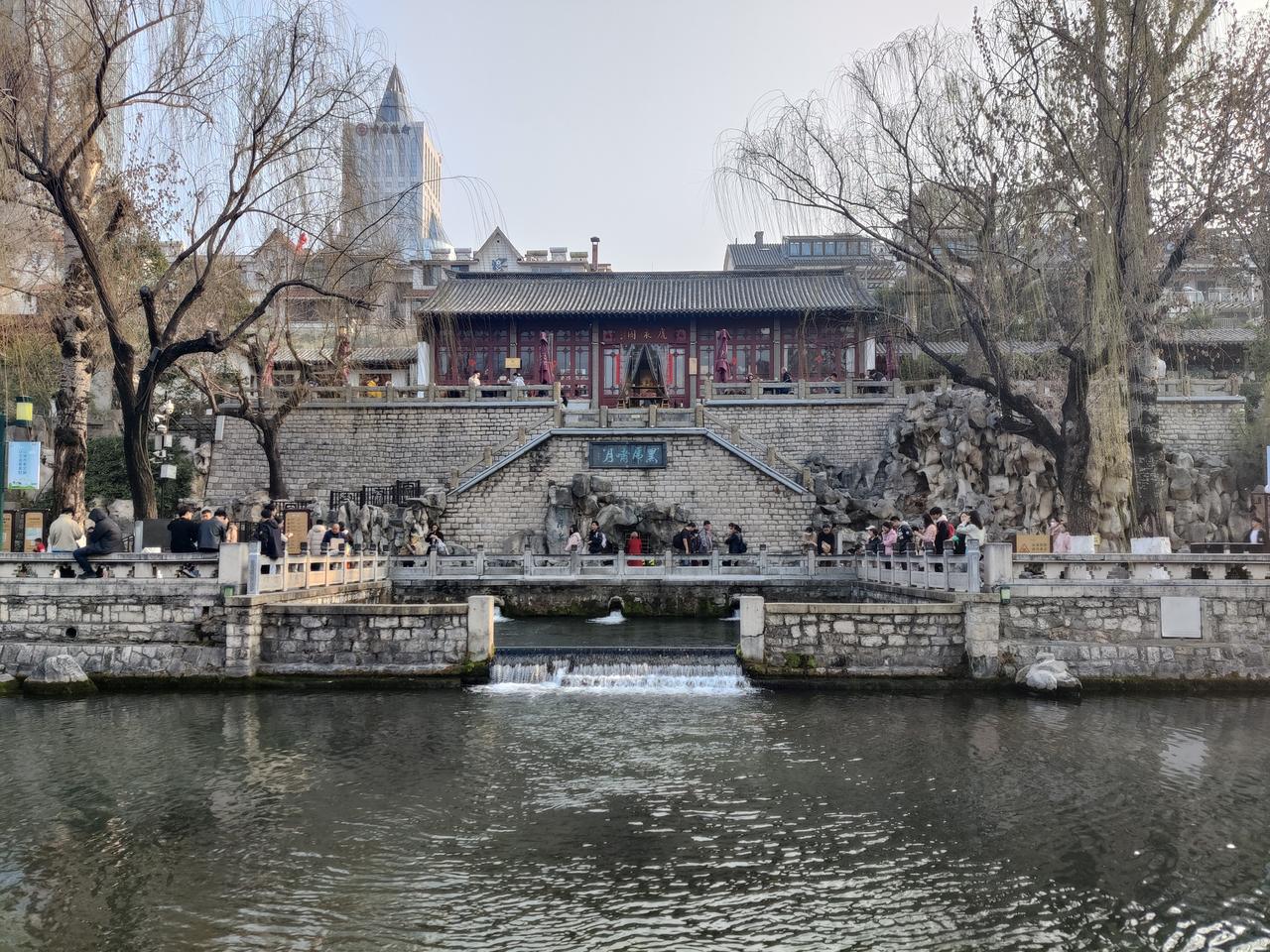 解放阁下护城河段的全景，黑虎泉水从南岸汇入河道，对岸是解放阁台基