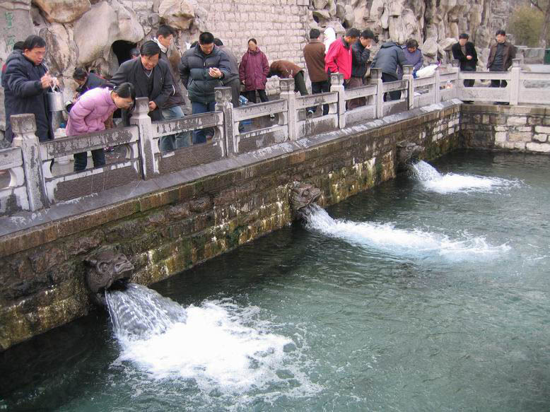 黑虎泉三只石雕虎头并列出水，泉水经暗渠从岩洞集流后由虎口喷入下方泉池