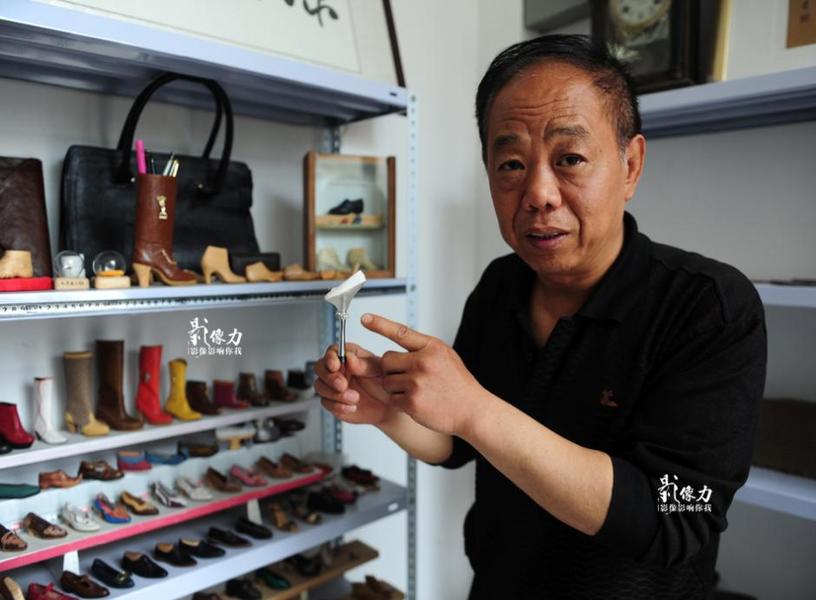 彭仕增在工作室中展示微型鞋作品
