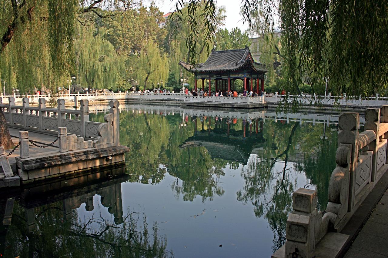 泉池全景,汉白玉栏杆环绕,远处浮玑亭探入水面