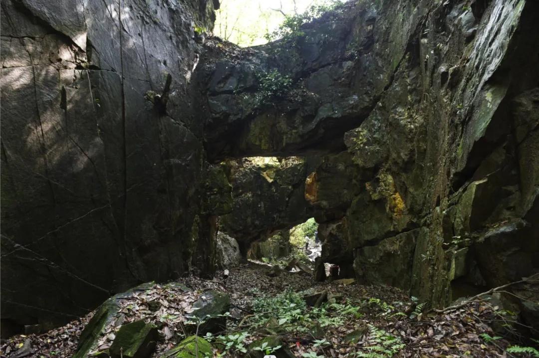 长岭瓷石矿遗址大午坑矿坑地貌，山体裂缝中可见青绿色瓷石矿脉