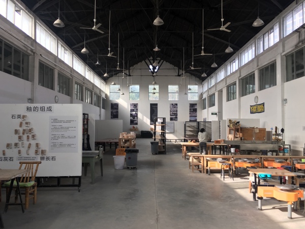 雕塑瓷厂内的陶瓷工作室内部，保留了老车间的层高和工业建筑的窗墙结构