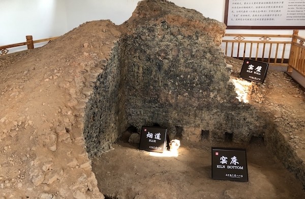 湖田窑遗址保护房内的窑炉遗迹，可见被高温烧结发黑的窑壁和底部的烟道结构