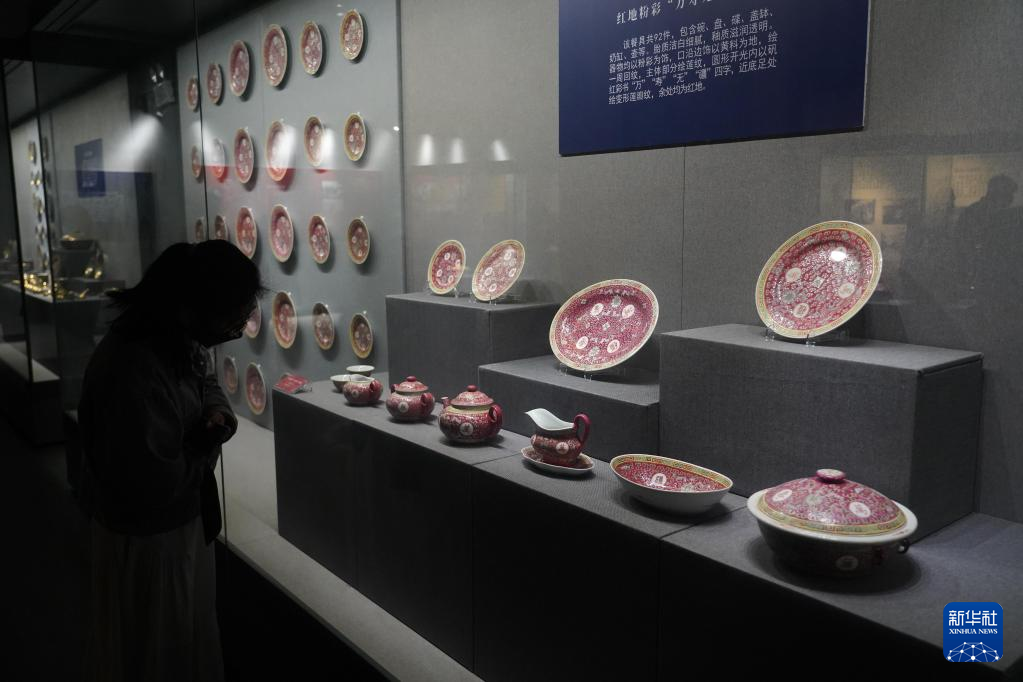 博物馆展厅内，观众正在欣赏陈列的陶瓷器皿