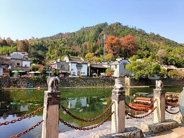 瑶河沿岸的古镇风貌,远处青山与近处徽派建筑倒映在清澈河水中