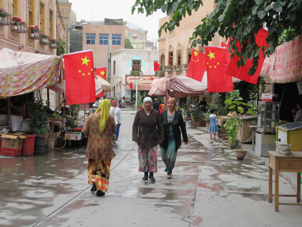 阿热亚路街景,沿街建筑悬挂国旗,底层为商铺