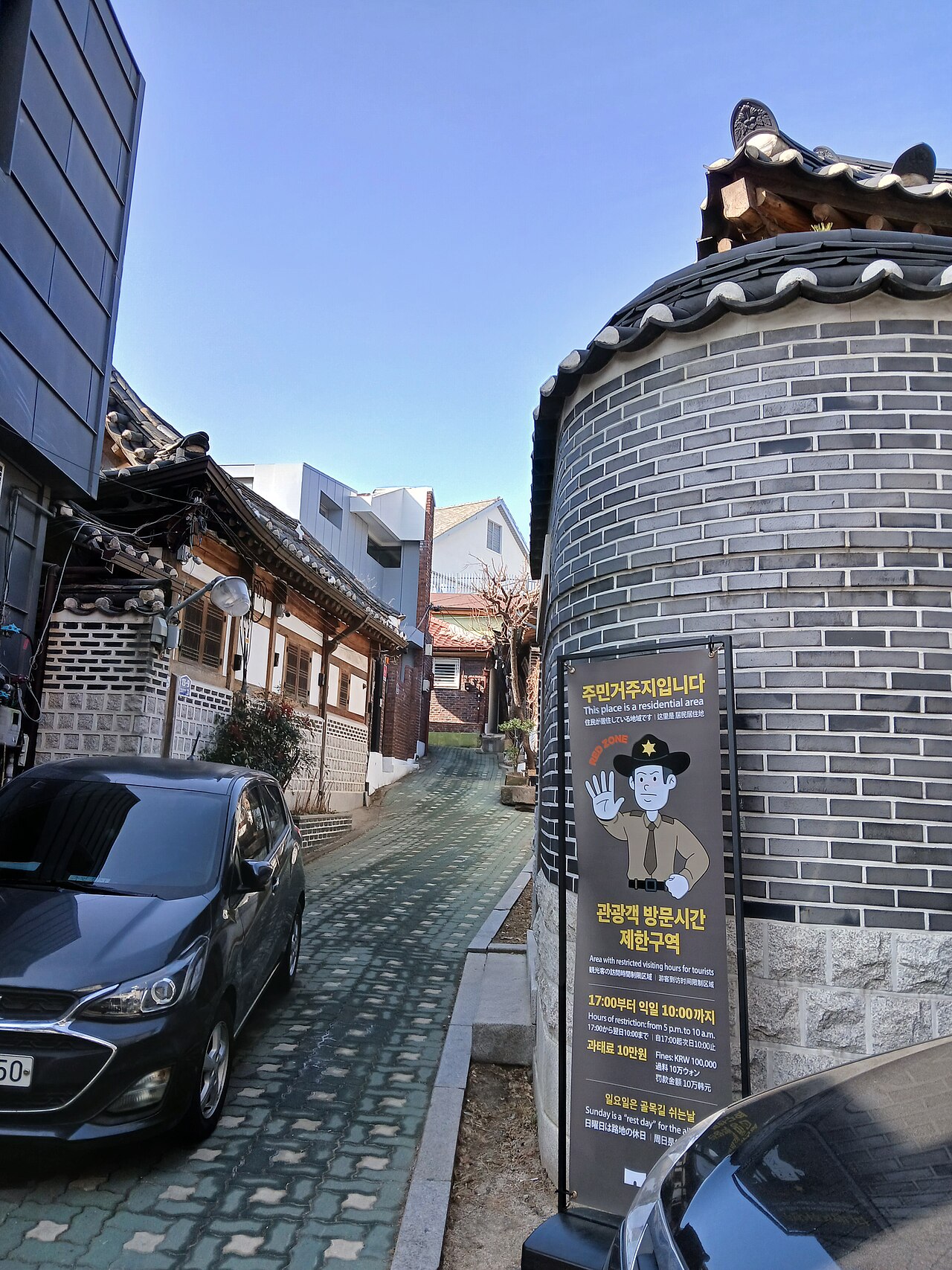 北村路11街红区入口处的官方管制信息牌，标注了观光时间限制和罚款金额