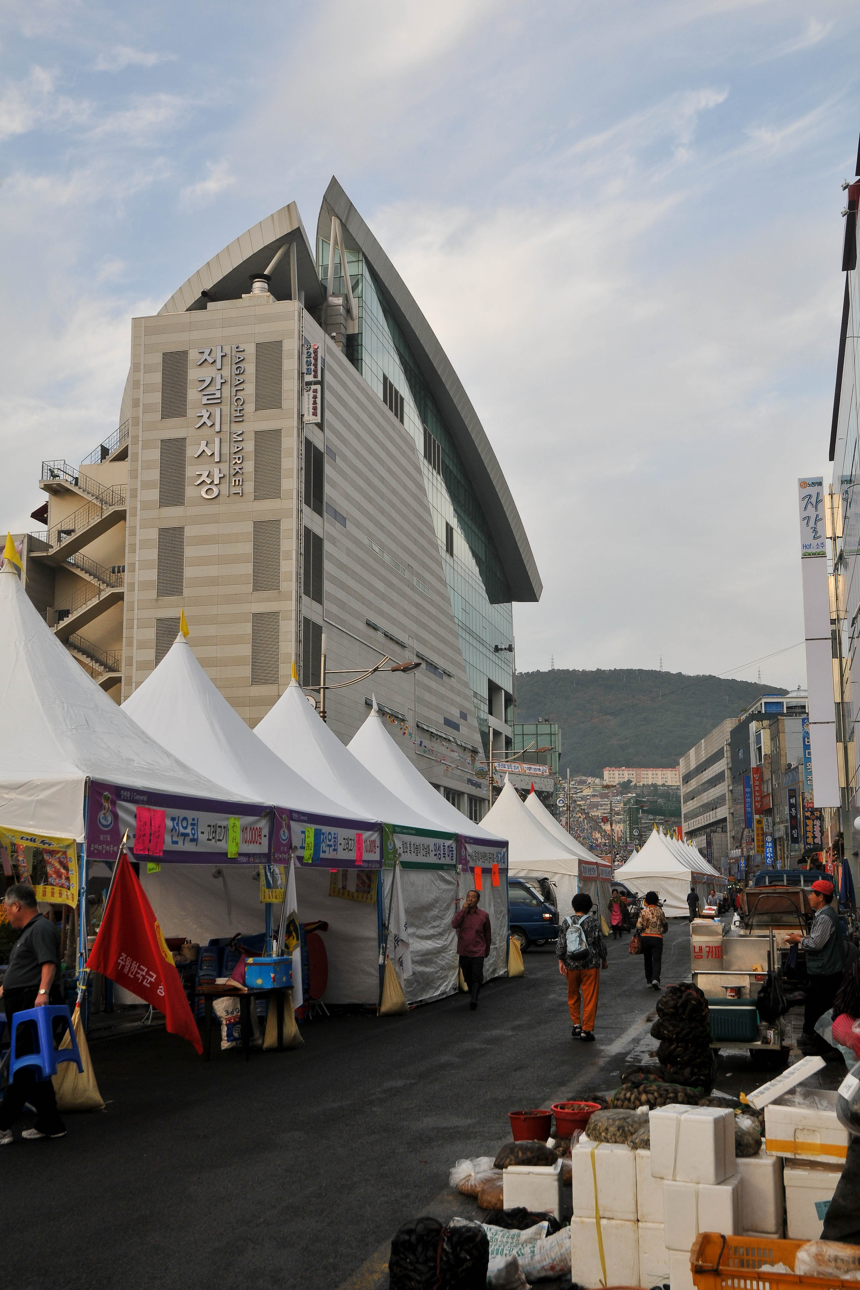札嘎其市场主楼外观，翼状屋顶和前方街摊