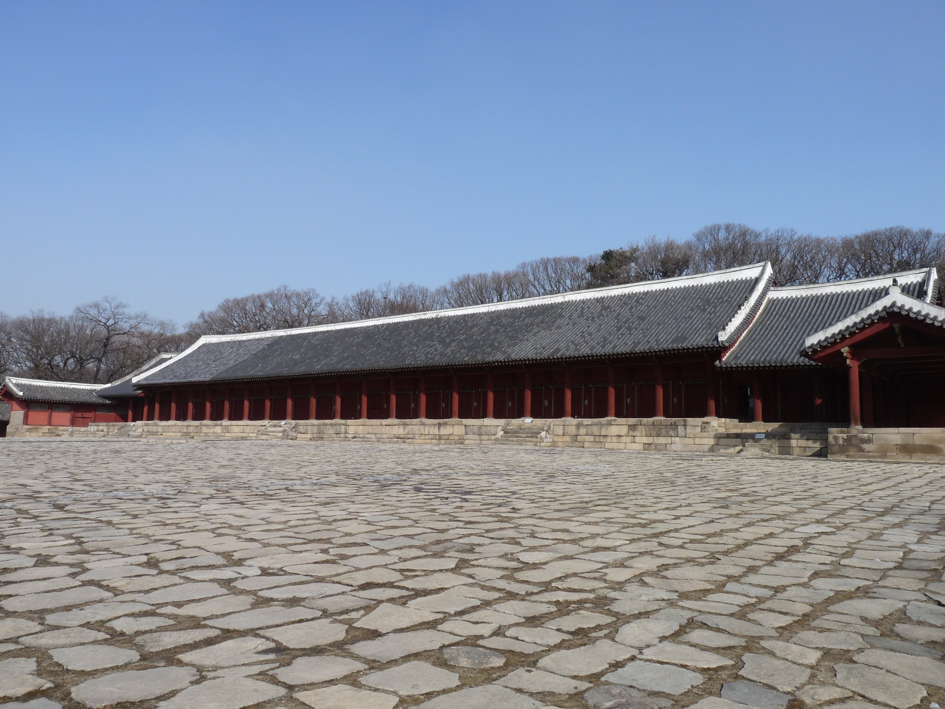 宗庙正殿（Jeongjeon）正面全景，19 开间一字排开，低矮的歇山顶和素面木柱清晰可见
