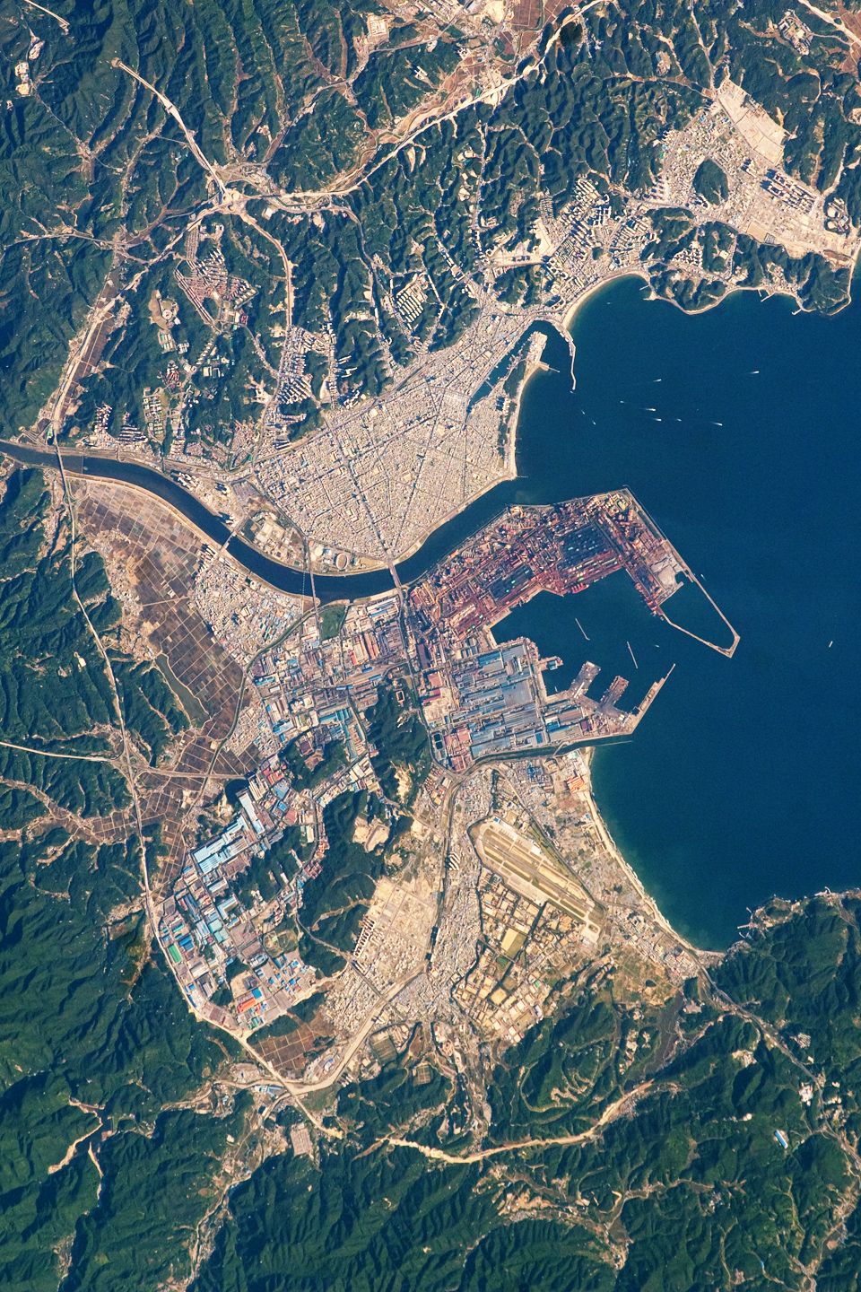 国际空间站拍摄的浦项城市与POSCO厂区太空照片，Hyeongsan河将城市分为西侧住宅区和东侧工业区