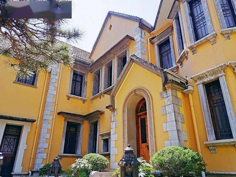 公馆正面全景，黄墙与石柱装饰