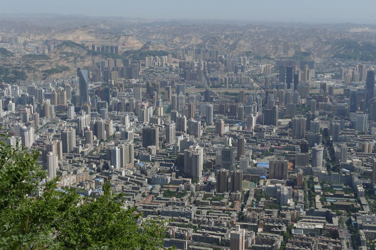 从皋兰山向北俯瞰兰州：城市沿黄河在南北两山夹缝中东西延伸