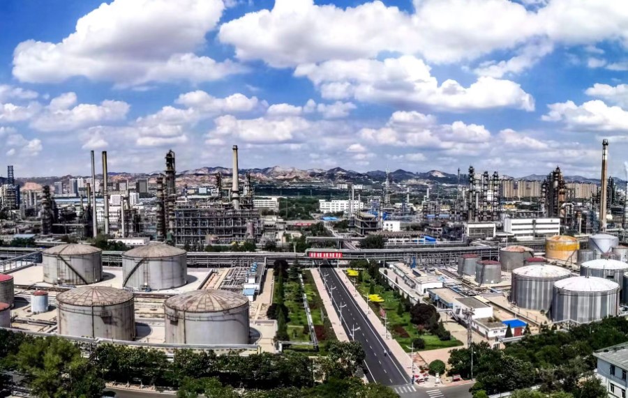 An expansive industrial complex with multiple large storage tanks, refinery stru