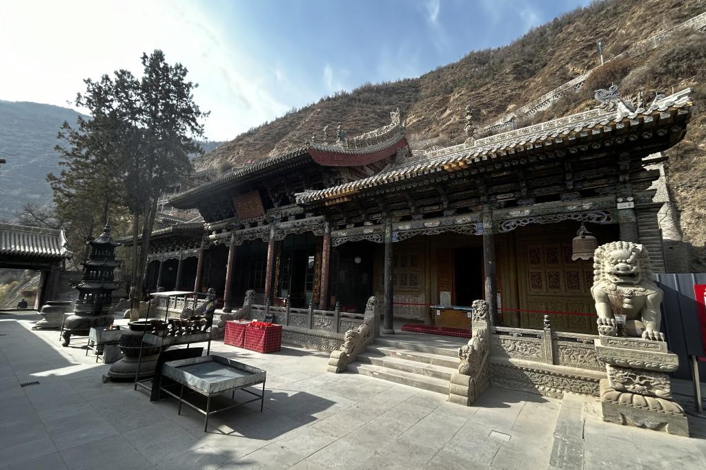 A traditional Chinese temple with intricate wooden carvings and stone lion statu