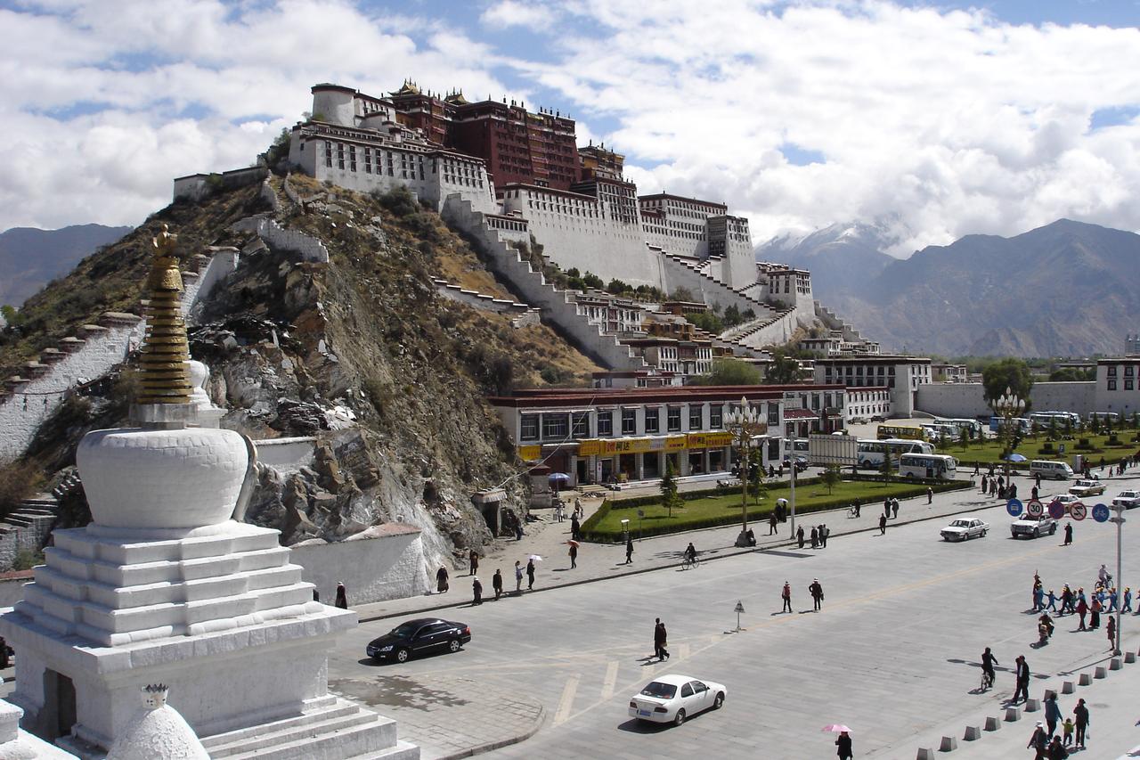 布达拉宫正面全景，广场倒影和低矮建筑形成对照