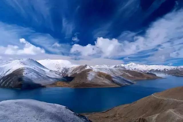 羊卓雍措湖面风光,远处雪山与蓝天倒映湖中