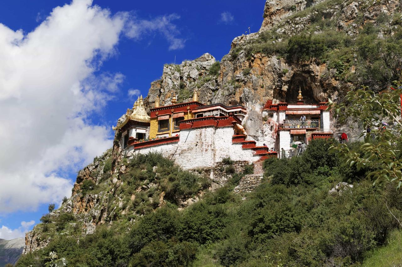 扎叶巴寺建筑群嵌在耶巴沟的石灰岩峭壁上，白墙红顶与山体融为一体