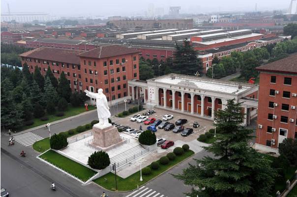 一拖厂区大门，凹字形红砖建筑正中上方金色厂名