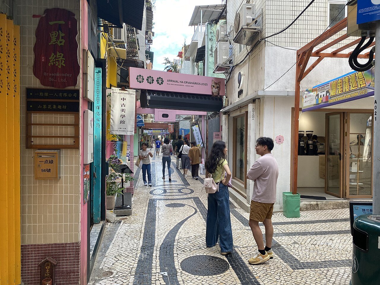 关前正街街景：窄巷两侧老式骑楼和新旧商铺并存，远处可见涂鸦墙面
