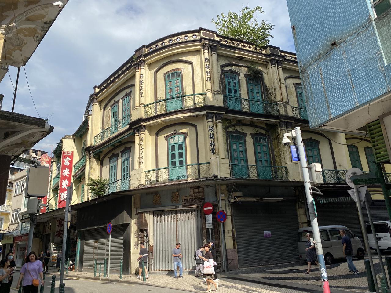 营地大街街景：狭窄街道两侧为旧式骑楼，地面层商铺、上层住宅