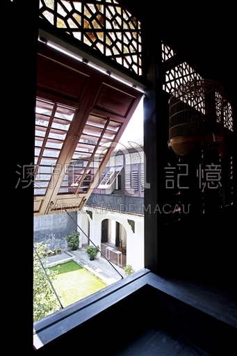 从室内窗口看内院：传统木窗与对侧拱门