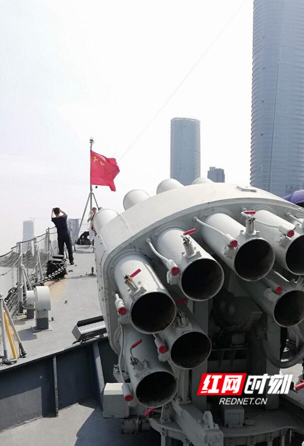 南昌舰甲板上的反潜火箭发射装置与城市天际线