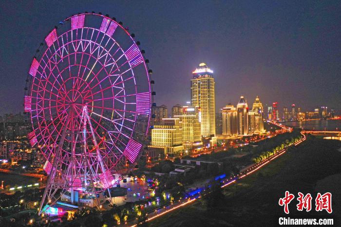 南昌之星摩天轮夜间灯光全景，轮面 LED 彩灯亮起，形成巨型彩色时钟