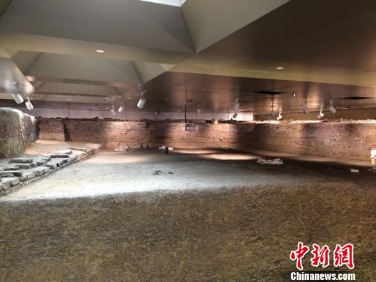 遗址发掘现场，可见分层夯土和砖石道路基址
