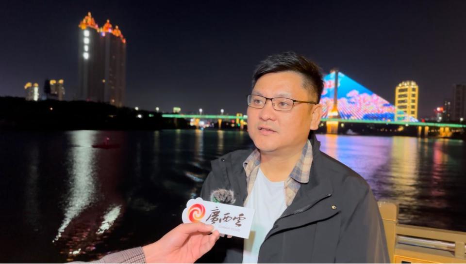 凌铁大桥以彩色灯光勾勒拱形结构，在江面上形成倒影。