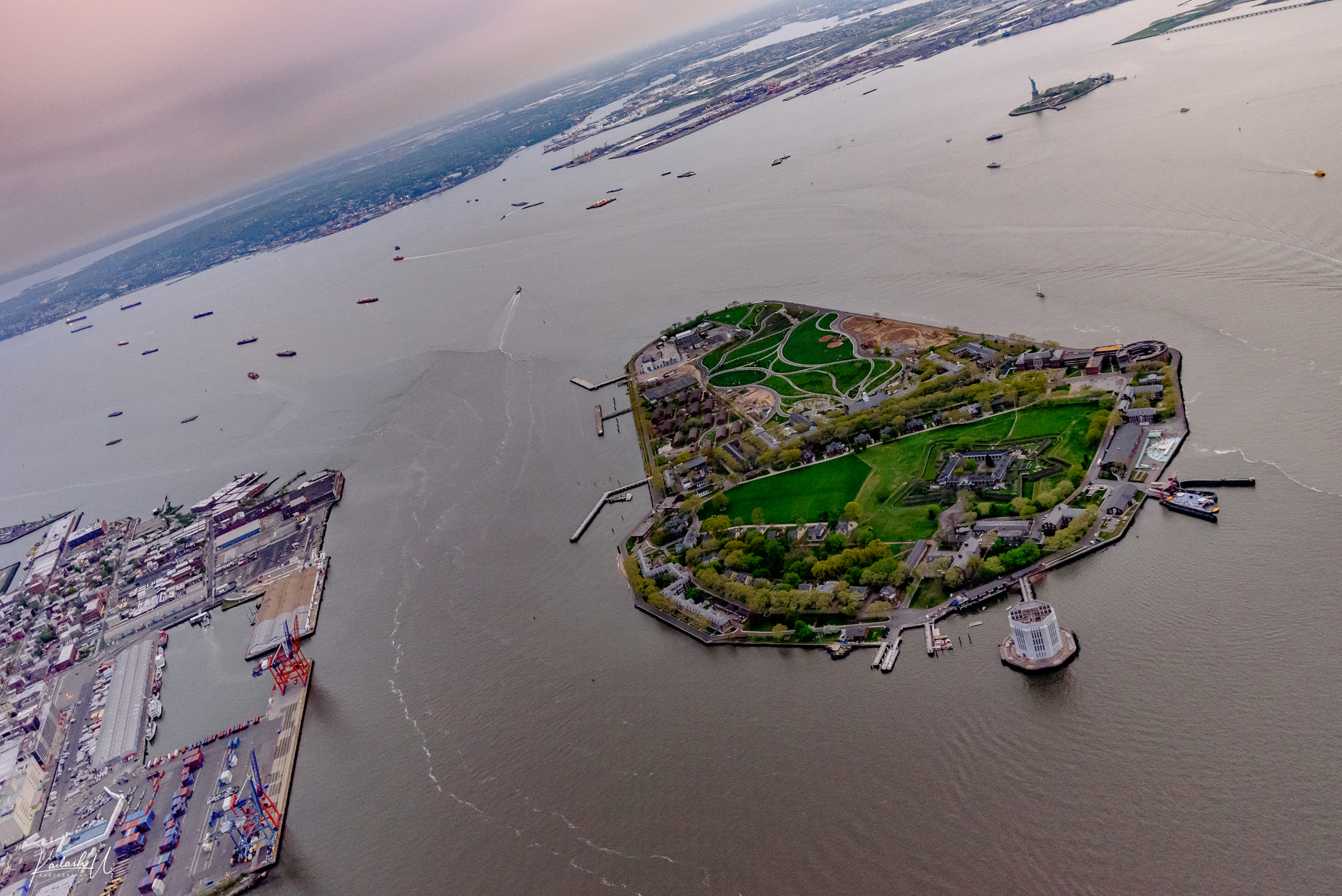 Aerial view of Governors Island at sunset, showing the historic north district and southern parkland