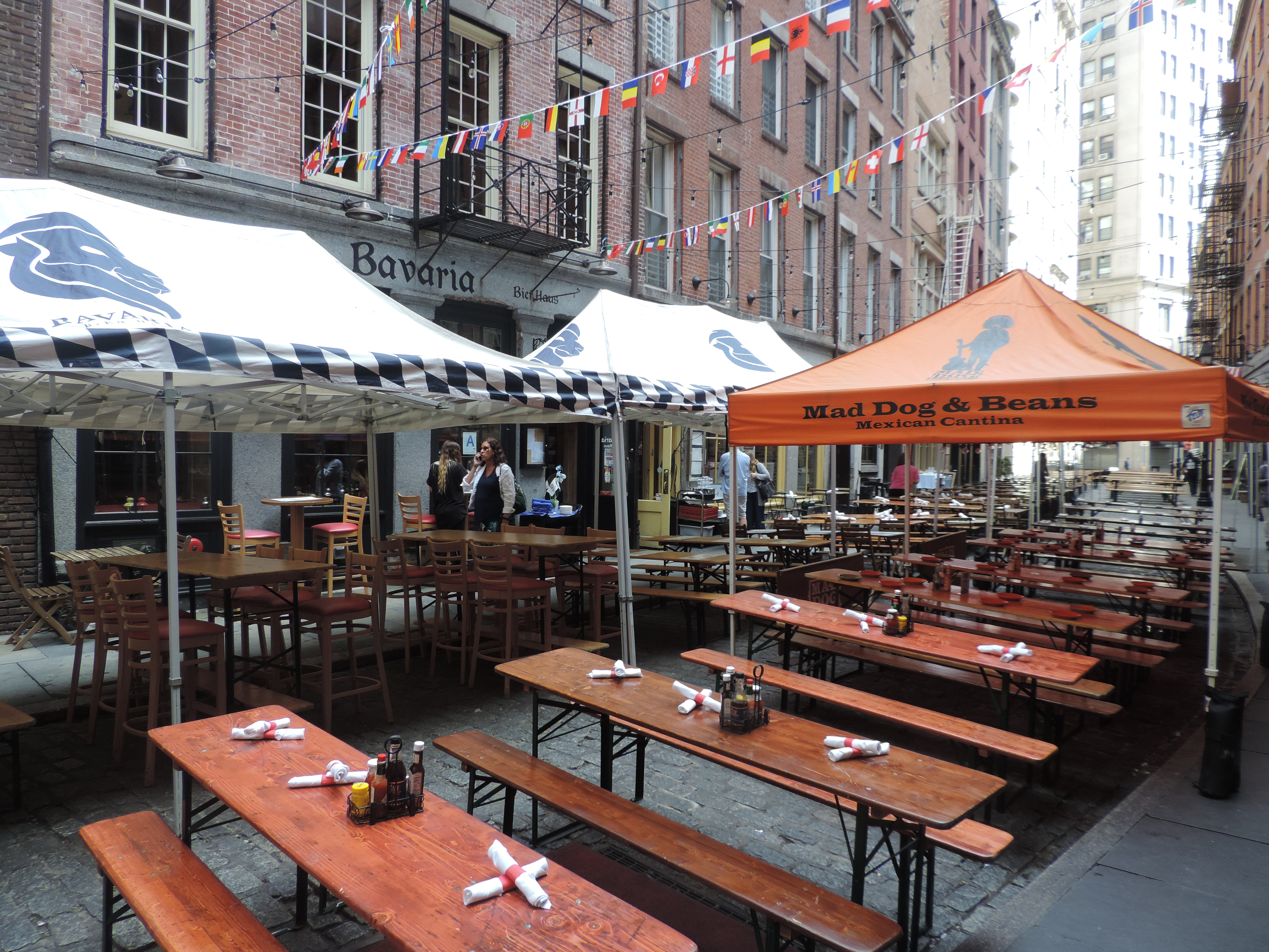 Stone Street 户外餐饮和串灯，左侧砖楼和右侧现代大厦形成对比