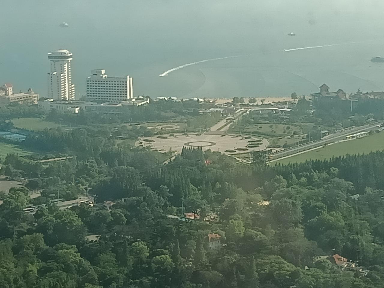 今日汇泉广场南侧的汇泉王朝大酒店和广场空间,远处可见第一海水浴场