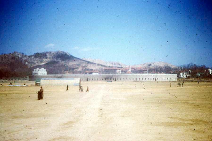 1940 年代美军航拍汇泉跑马场,椭圆形跑道轮廓完整,东侧是青岛第一体育场