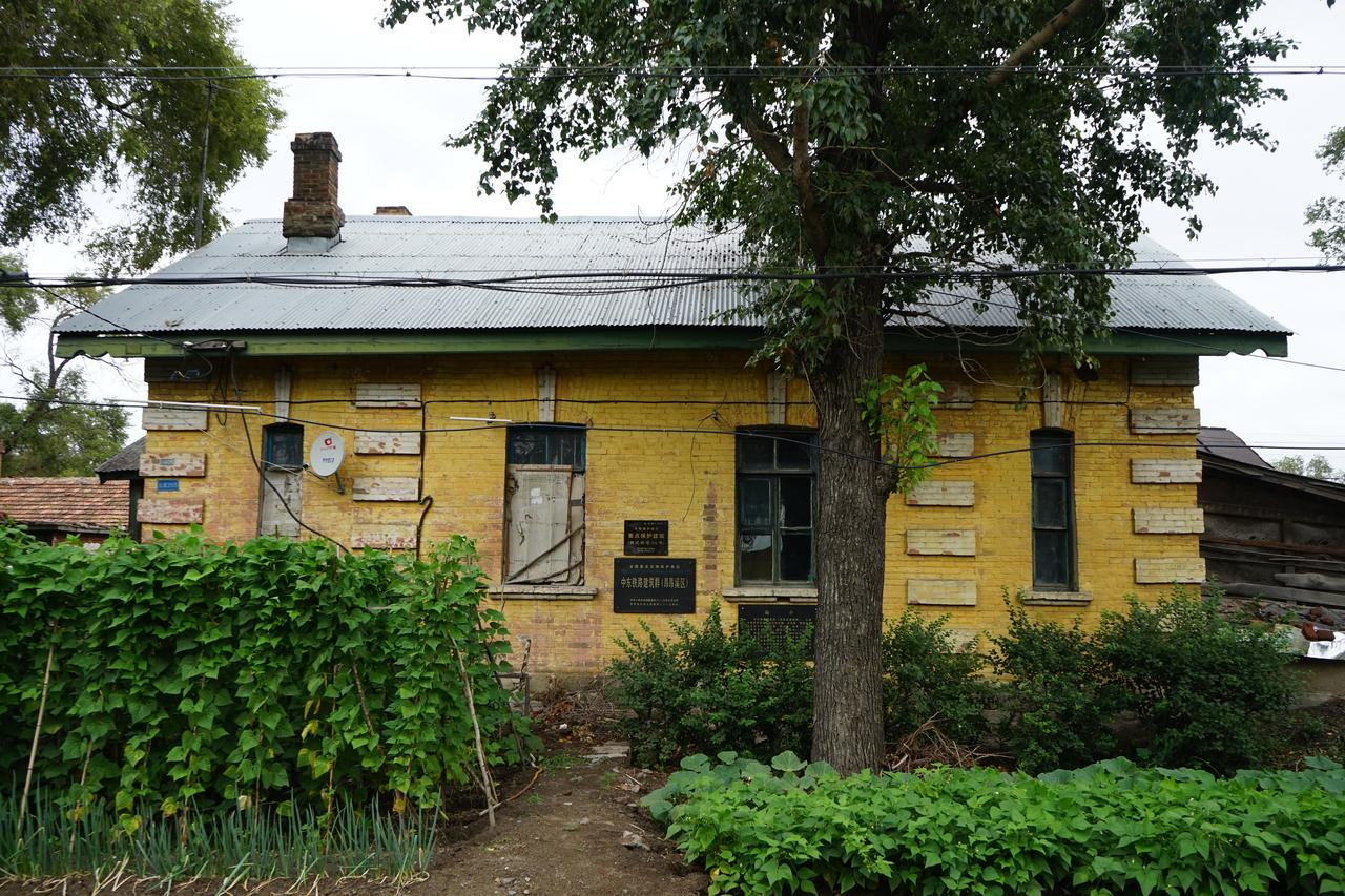 罗西亚大街两侧的俄式住宅，黄墙白窗，铁皮坡顶，每栋带独立庭院和木制门斗